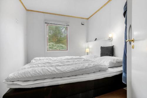 a bedroom with a large bed with white sheets at 84230-Ebeltoft-Skovduevej-10 in Ebeltoft