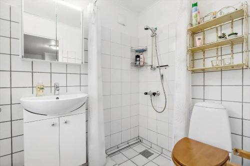 a white bathroom with a sink and a toilet at 84230-Ebeltoft-Skovduevej-10 in Ebeltoft