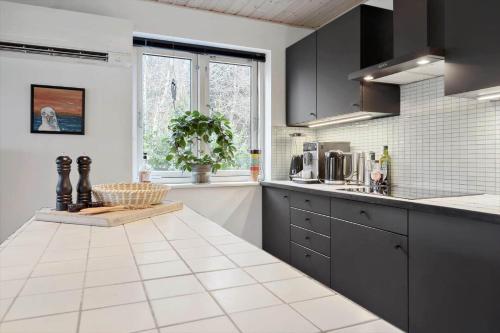 a kitchen with black cabinets and a white counter top at 84231-Ebeltoft-Magevej-50 in Ebeltoft