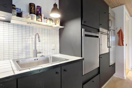 a kitchen with a sink and a refrigerator at 84231-Ebeltoft-Magevej-50 in Ebeltoft