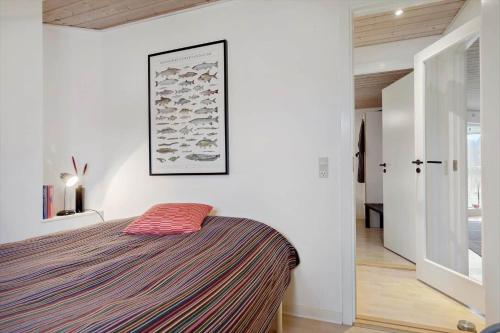 a bedroom with a bed and a picture on the wall at 84231-Ebeltoft-Magevej-50 in Ebeltoft