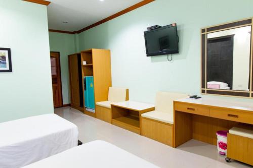 Zimmer mit einem Bett und einem TV an der Wand in der Unterkunft Baan Ingna Resort Hotel in Chaiyaphum