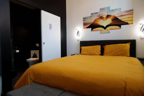 a bedroom with a yellow bed and a bathroom at SEE - Gare de Marly in Valenciennes