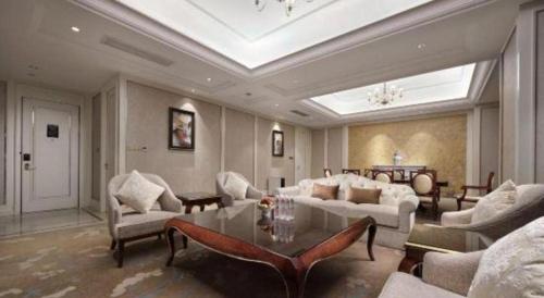 a living room with a couch and a table at Dongwu New Century Grand Hotel Huzhou in Huzhou
