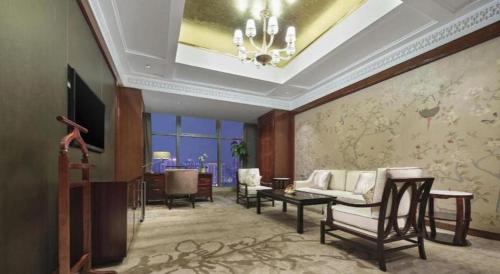 a living room with a couch and a table at Dongwu New Century Grand Hotel Huzhou in Huzhou