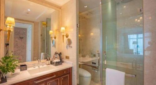 a bathroom with a shower and a sink and a toilet at Dongwu New Century Grand Hotel Huzhou in Huzhou