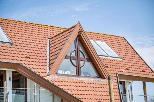 an extension to a house with a roof with a window at Moin Moin in Friedrichskoog-Spitz