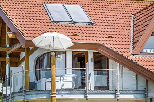 a porch with an umbrella on a house at Moin Moin in Friedrichskoog-Spitz