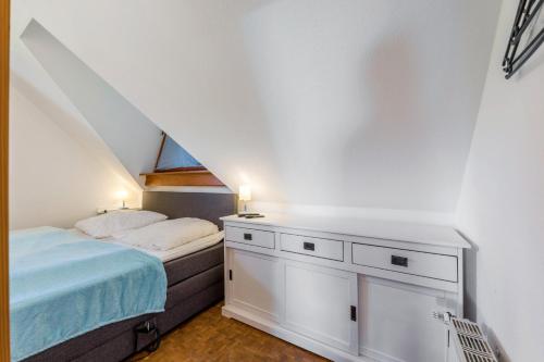 a small bedroom with a bed and a dresser at Moin Moin in Friedrichskoog-Spitz