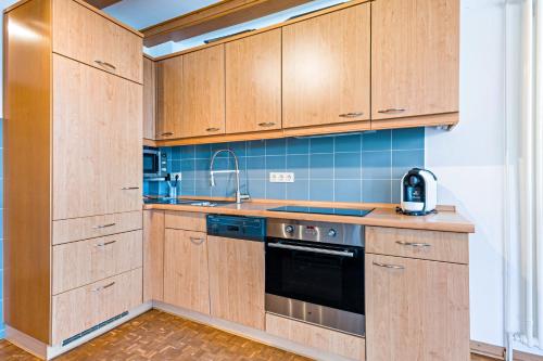 a kitchen with wooden cabinets and a sink at Moin Moin in Friedrichskoog-Spitz