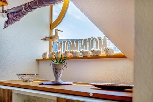 a shelf with a vase with stuffed animals on it at Moin Moin in Friedrichskoog-Spitz