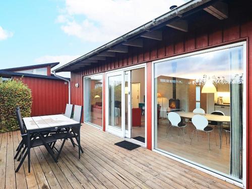 a patio with a table and chairs on a deck at Scenic Golf Retreat-By Traum in Bogense