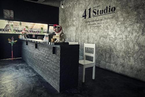 a dog sitting on top of a bar with a chair at 41Studio in Nakhon Phanom