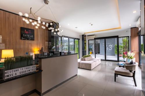 a lobby with a reception counter and a couch at Gate43 Airport Hotel in Lat Krabang