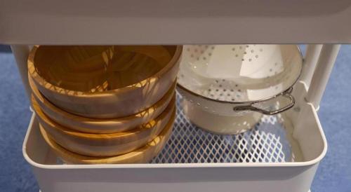 a drawer filled with plates and bowls with a spoon at CS Premier Hotel in Seoul