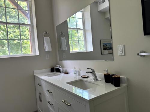 a white bathroom with a sink and a mirror at Burk's Fall River View 2b2b in Burks Falls