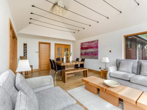 una sala de estar con un sofá y una mesa en Corrie Burn Villa, en Ullapool