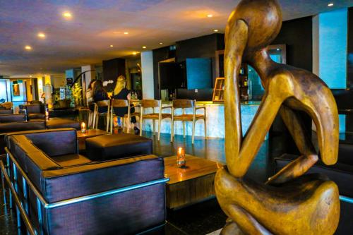 uma estátua de uma mulher sentada num restaurante em Ritz Lagoa da Anta Hotel & SPA em Maceió