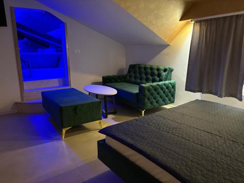 LepenicaにあるCamellia apartmentsのベッドとソファと椅子のある寝室