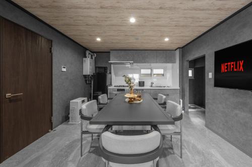 ein Esszimmer mit Tisch und eine Küche in der Unterkunft The Exstra in Otaru