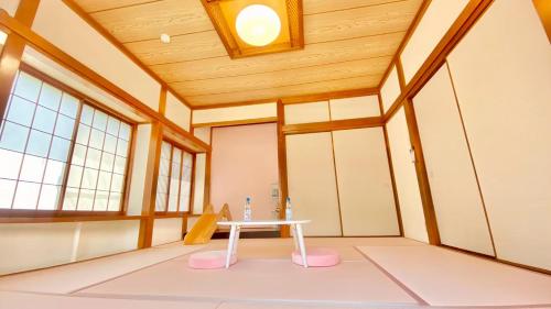 a table in the middle of a room with a ceiling at Spacious Family Home Near Beach Park & Playground in Hasunuma