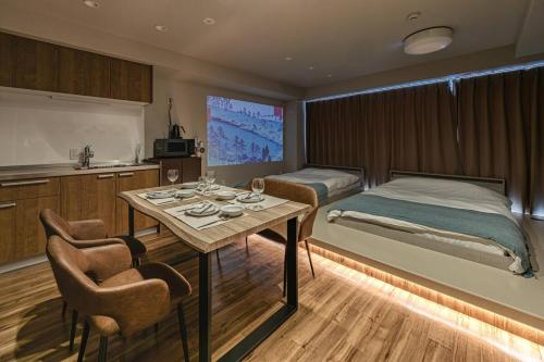 a bedroom with a bed and a table and a kitchen at 365Ueno in Tokyo