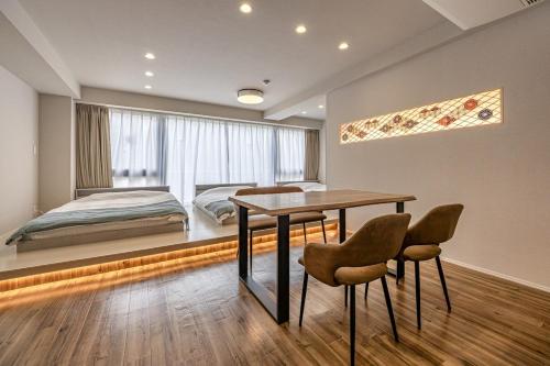 a bedroom with a bed and a table and chairs at 365Ueno in Tokyo