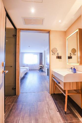 a bathroom with a sink and a bed in a room at Hanting Hotel Beijing South Railway Station Center in Beijing