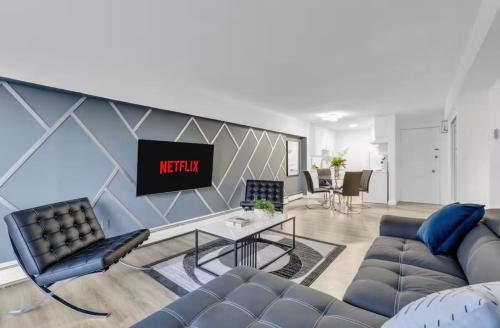 a living room with a couch and a tv at 17th Ave Cozy Nest in Downtown Calgary with Parking in Calgary