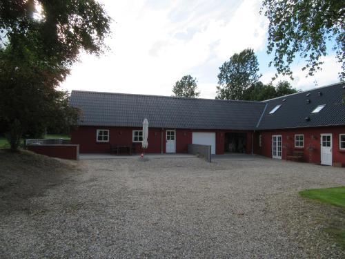 a red barn with a large driveway in front of it at Hedelodden Apartment in Uve