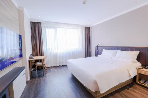 a hotel room with a large bed and a television at Hanting Hotel Beijing South Railway Station Center in Beijing
