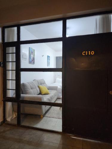 a living room with a couch through a sliding glass door at TVHStays premium apartments in Nairobi