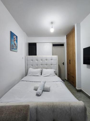 a bedroom with a large white bed with two pillows at TVHStays premium apartments in Nairobi