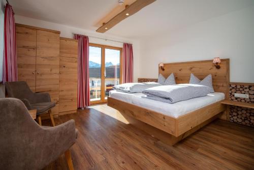 ホプフェラウにあるLandhaus Brunner Beim Veitのベッドと大きな窓のある寝室