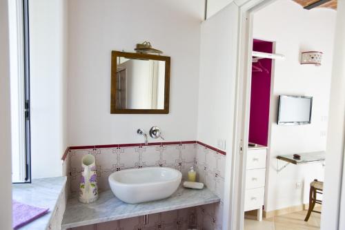 a bathroom with a white sink and a mirror at La Via del Carretto B&B in Capri Leone