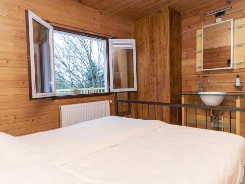 a bedroom with a bed and a sink and a window at Chalet in Manhay for 9 Person in Manhay