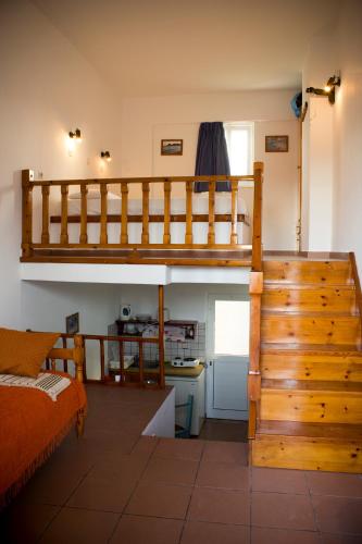a bedroom with a loft bed and a kitchen at Level Houses in Kefalos