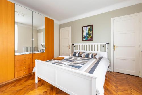 a bedroom with a white bed and a large mirror at Grand appartement de charme proche Paris in Athis-Mons
