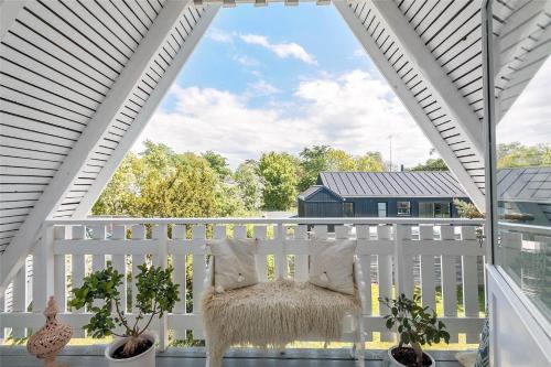 a white pergola with a chair on a porch at 1319-N-Liseleje-Liselejevej-55 in Liseleje