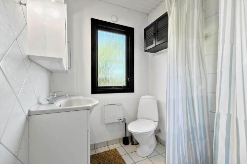 a bathroom with a toilet and a sink and a window at 8804-Glesborg-Vesttoften-20 in Glesborg