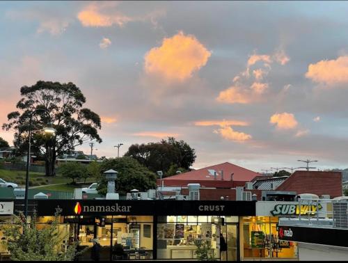 a store in a city with a cloudy sky at Kingston Stylish Villa-Cozy meets convenience in Kingston