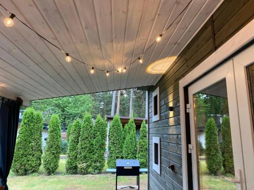 a porch with a wooden ceiling with lights on it at Silumetras in Ventspils
