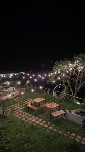 a group of picnic tables in a park at night at Himadvaya- The Himalayan Prism in Almora