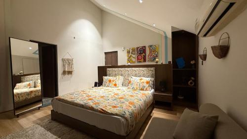 a bedroom with a bed and a large mirror at Himadvaya- The Himalayan Prism in Almora