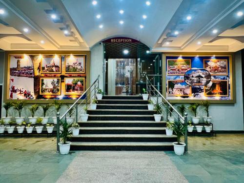 a lobby with stairs and potted plants in a building at Hotel Ramawati, Top Rated & Most Awarded Hotel In Haridwar in Haridwār