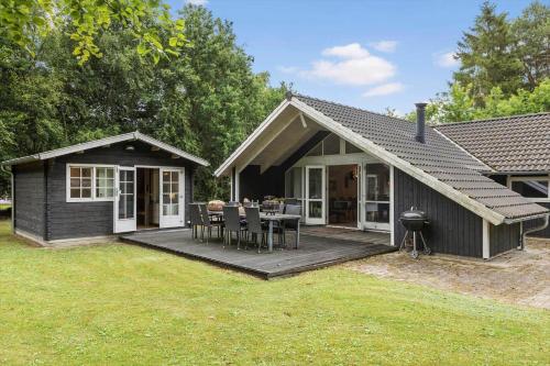 a house with a deck with a table and chairs at 946-Frederiksvaerk-Skelvaenget-3-a in Frederiksværk