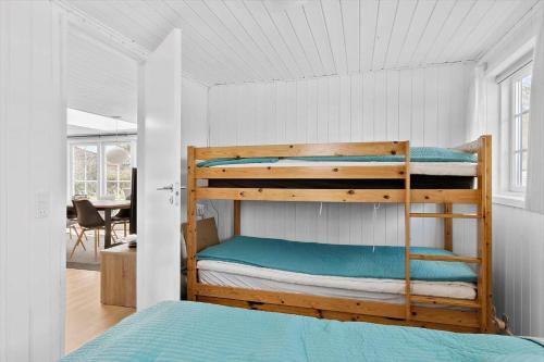 BL856-Blokhus-Soren-Tjenersvej-2 في بلوكهوس: غرفة نوم بها سريرين بطابقين في الغرفة