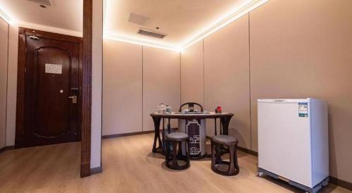 a room with a small table and a refrigerator at Chengdu Haotian Guotai Hotel in Chengdu