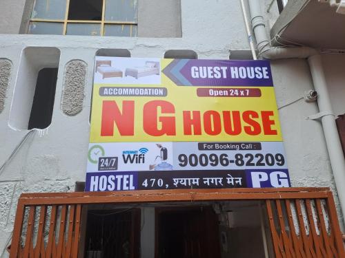 a guest house sign on the side of a house at Narmada Guest House in Indore