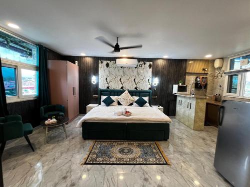 een slaapkamer met een groot bed en een keuken bij The Scenic Roofhouse by Amrove near Rajpur road in Dehradun
